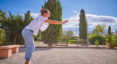 Femme jouant à la pétanque dans un camping écologique