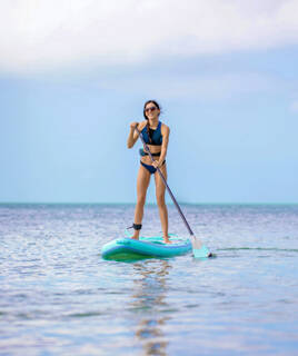 Jeune femme faisant du paddle en mer