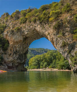 Vue majestueuse du Pont d'Arc, arche naturelle emblématique des Gorges de l'Ardèche, avec la rivière en contrebas.