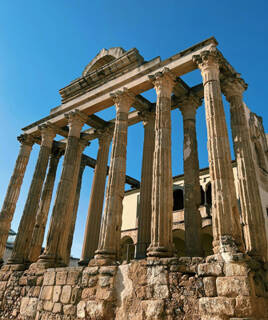 Les imposantes ruines romaines du Temple de Diane à Nîmes, avec ses colonnes corinthiennes se dressant sous un ciel bleu clair.