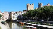 Le Canal de la Robine traversant le centre historique de Narbonne, avec ses bâtiments et ses bateaux.