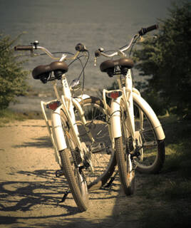 Deux vélos blancs garés sur une piste cyclable, avec la mer en arrière-plan, sur l'Île de Noirmoutier.