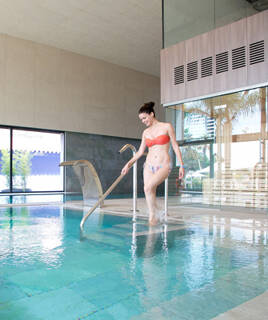 Femme souriante sortant d'une piscine de balnéothérapie.