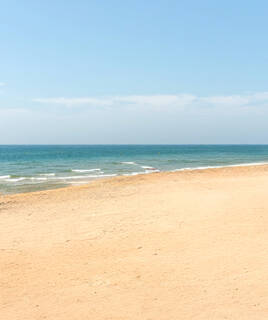 Plage de sable vide et mer calme, sur la plage de la Corniche à Sète.