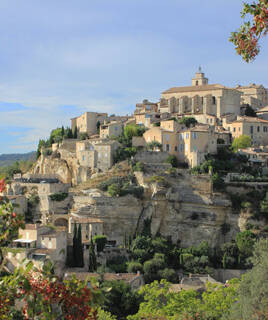 Paysage vallonné et verdoyant de la Provence, avec des champs et des cyprès, dans le Vaucluse.
