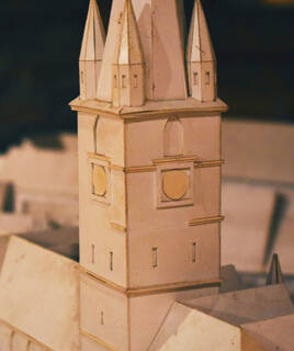 Une maquette détaillée d'une tour de cathédrale en carton, exposée au Cathédraloscope de Dol-de-Bretagne, avec des pinacles pointus et des détails architecturaux.