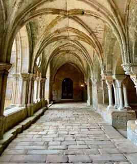 L'intérieur voûté en pierre de l'Abbaye de Fontfroide, près de Port-La-Nouvelle, avec ses arches gothiques et son sol pavé, baigné par la lumière naturelle.