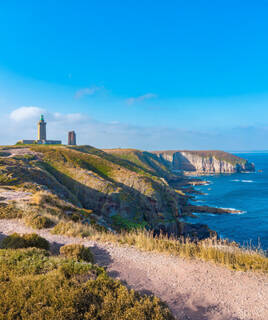 Le Cap Fréhel, une spectaculaire falaise rocheuse, avec son phare et une ancienne tour en ruine.