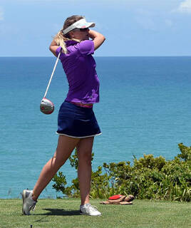 Femme jouant au golf face à l'océan à Biarritz