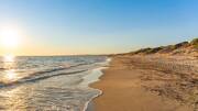 plage de sable fin , avec une mer calme sous un ciel bleu